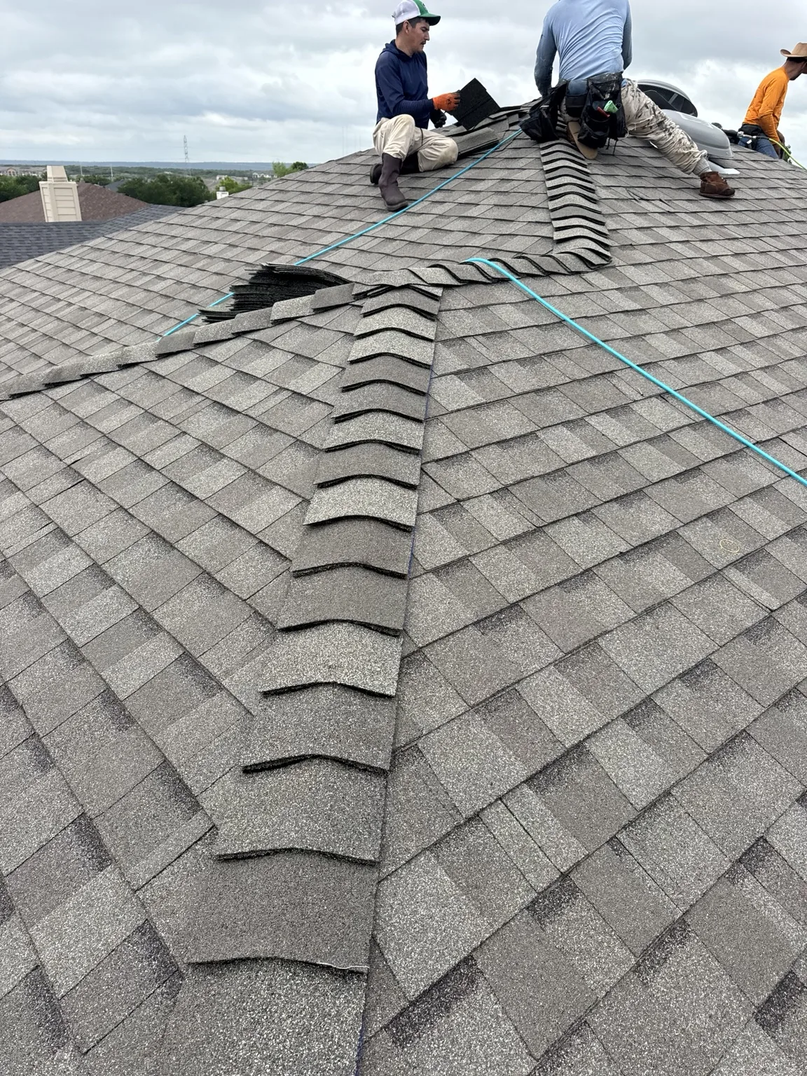 Roofing crew installing shingles